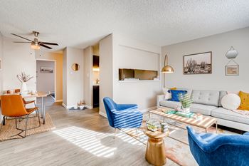 A living room with a white couch, blue armchair, and a coffee table.